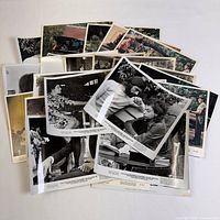 Pile of vintage movie publicity photos in mixed black and white and color, stacked and fanned out