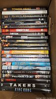 Photo of a stack of assorted DVDs showing titles like Tower Heist, Robin Hood, Cinderella Man, Ocean's Thirteen, King Kong and more.