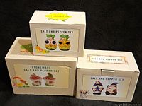 Three boxes containing Cracker Barrel salt and pepper sets: pineapple, mushroom, and gnome designs.