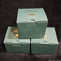 3 green Harmony Kingdom Treasure Jests boxes stacked showing brand and series name on box.