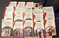 Photo of 19 Harlequin Presents romance paperback books arranged in rows showing covers and titles.