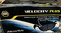 Photo of the box labeled Velocity Plus premium shimmed metallic disc brake pads by NTA showing branding and product type.
