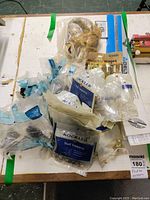 Top view of multiple Rockler accessory packages and some loose parts showing shelf supports and invisible hinges.