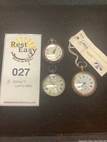 Three pocket watches shown with a card displaying lot number and description.