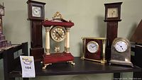 Group of five clocks on shelf