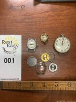 Overview of all items including stopwatch, two watch cases, disassembled parts and lot card