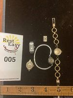 Group view of all five items on black background with ruler and Rest Easy card