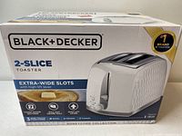 Box front view showing the Black & Decker 2-slice toaster with extra-wide slots and honeycomb design.