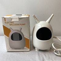 Electric balloon pump HY002 next to its original box showing front and side view