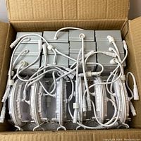 Box containing 12 LED recessed lights with attached junction boxes and connecting wires, showing the lot's contents and quantity.