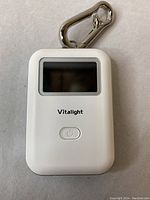 Front view of white Mini CO2 Detector with LCD screen and power button, featuring Vitalight branding and silver metal clip.