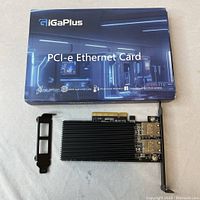 Photo showing AigaPlus branded original retail box for PCI-e Ethernet Card placed above the card and a low profile mounting bracket beside the card.