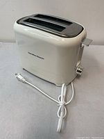 Side view of white Hamilton Beach 2-slice toaster showing power cord and adjustable browning knob