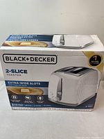 Front of the box showing brand, model, and key features like 2-slice capacity, extra-wide slots, and honeycomb collection design.