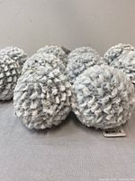 Close-up of fuzzy white Christmas ornaments showing texture and detailing.