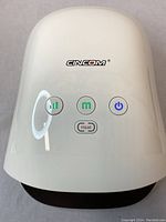 Top view of white Cincom hand massager showing logo and control buttons labeled power, mode, intensity, and heat.