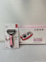 Photo of pet hair brush in original plastic packaging and boxed penguin dog bowl