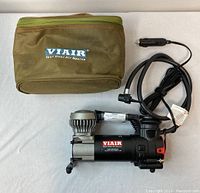 Portable compressor tire pump with hose, power cable, and olive green carrying case