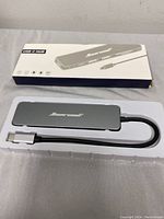 Boxed 6-in-1 USB C hub with attached USB C cable in plastic tray, front view showing brand Monorail.