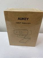Front view of sealed Aukey 1080P Webcam box showing product name and drawing of the webcam