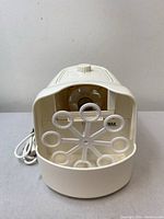 Front view showing the circular bubble wand mechanism with nine circular rings for bubble production inside a plastic housing.