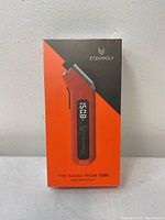 Front view of the sealed box showing Etenwolf Tire Gauge Probe T300 in orange and black packaging, displaying a digital reading on device illustration.