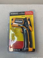 Front view of the Sovarcote HS960D Infrared Thermometer sealed in blister packaging showing product and branding with callouts