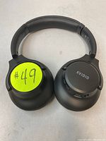 Front view of black Kvidio Bluetooth over-ear headphones with padded headband and ear cups, showing the numbered lot sticker on one ear cup.
