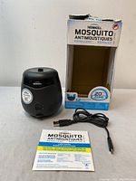 Thermacell mosquito repellent diffuser with USB cable, instruction sheet, and original box shown on a neutral background.
