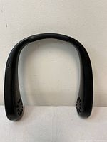 Front view of the black neck fan showing the two fans on each end and padded section on top for comfort.