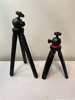 Two mini tabletop tripods on a flat surface, showing their relative size and features.