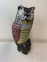 Full view of the owl-shaped solar powered scarecrow showing colored details and base