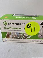 Box front and side showing Symynelec branding, product name, and advertising features including waterproof rating and suitable for indoor/outdoor use.
