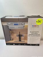 Box front showing image of the Proscan under-counter unit, display screen, control buttons, logo, and features.