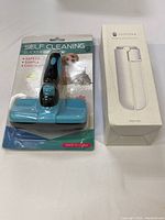 Photo of the self-cleaning sticker brush in original packaging, blue and black color, with packaging showing dog and cat images.