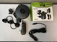 AGPTEK electric air pump, three nozzles, power adapters and original box shown from above on table.