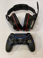 Top-down view of the wireless gaming headset with red accents and wireless gaming controller with blue detailing on a white background.
