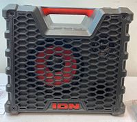Front view of black and red rugged portable speaker with honeycomb mesh grille and ION logo at the bottom