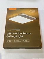Packaging box front view showing brand Narundren, LED Motion Sensor Ceiling Light description, 2 pack, and feature icons (motion sensor, 3 color temperatures, high brightness).