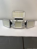 Front view showing four LED panels with multiple LEDs and two round motion sensors on the central panel.