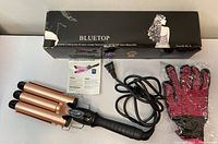 Three barrel hair curler with cords, heat-resistant glove, instruction manual, and original box placed on white surface.