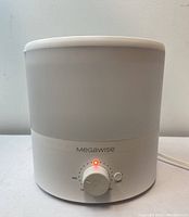 Front view of white Megawise ultrasonic humidifier showing control knob with red LED light indication and power button.