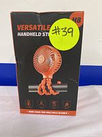Front of the box showing orange mini stroller fan with flexible legs attached to a bar and branding text.
