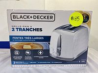Front of the Black+Decker toaster box showing the toaster with textured honeycomb design, two wide slots, and various features.