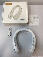 Full set including the white wearable neck fan, USB charging cable, user manual, and packaging box