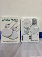 Photo of two Wtuhu magnetic wireless chargers fully displayed in packaging showing charging pads, USB adapters, and cables.