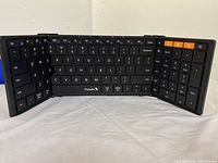 ProtoArc Mini folding Bluetooth keyboard opened, showing 3-section fold design and key layout