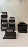 Two stacks of black rectangular solar garden lights and one stack of flat base pieces, showing front and side views of the lot.