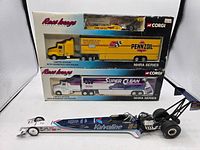 Image showing the four item lot with a 1:24 Valvoline dragster and three Race Image NHRA series trailers in boxes