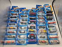 Four vertical rows of Hot Wheels vehicles in original card and blister packaging, totaling 38 units. Packaging shows minor wear but all are factory sealed.
